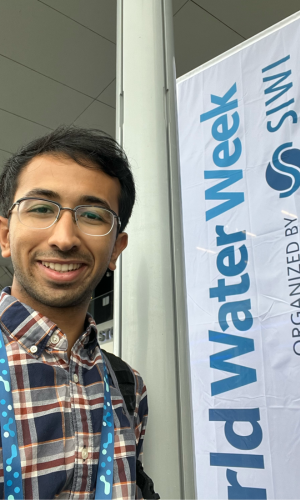 Arjav Shah with white banner that reads World Water Week SIWI in blue letters