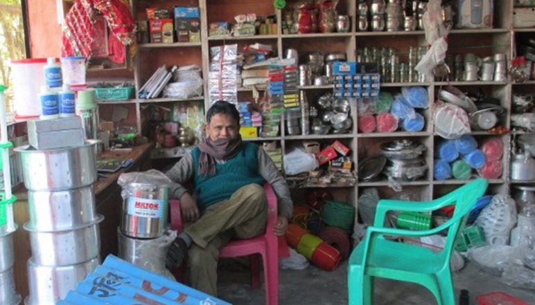 Man sitting in chair in shop that sells water sanitation products