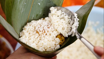 Rice being scooped in leaf bowl