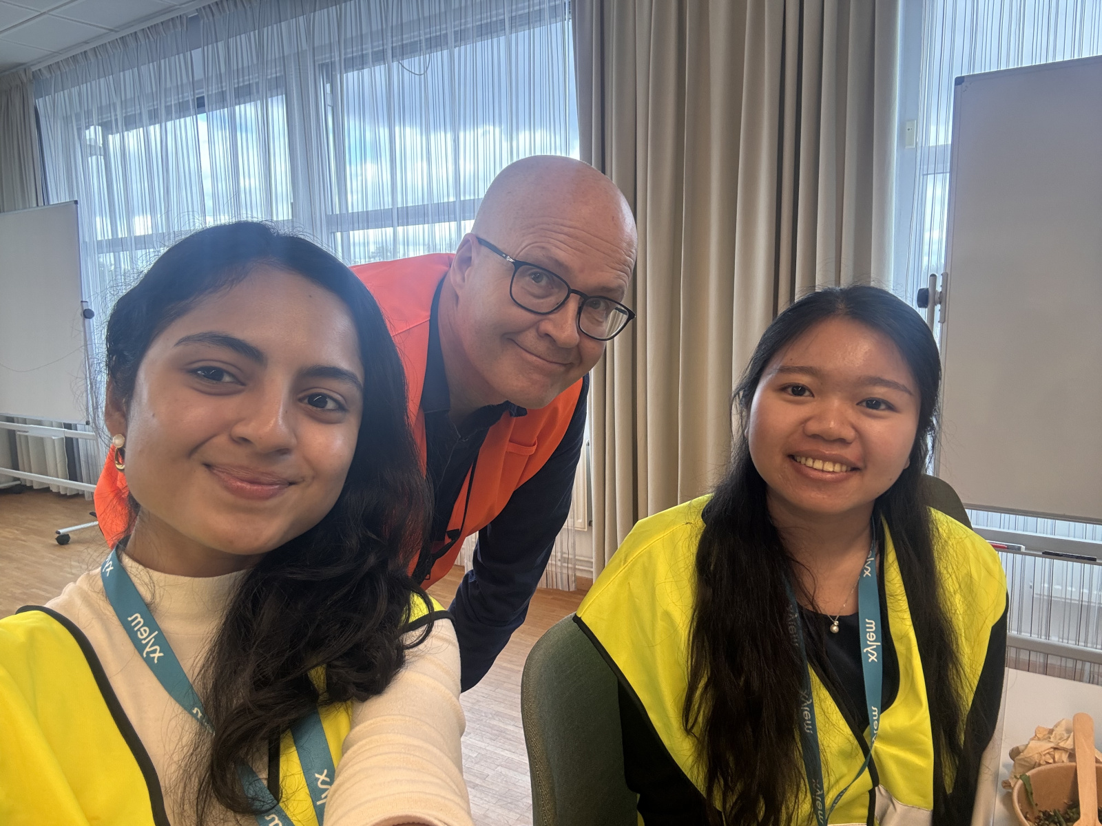 Priyanka and Hao in yellow tech vests with Jan Backer between them