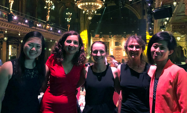 All five J-WAFS representatives in fancy dress in front of chandelier
