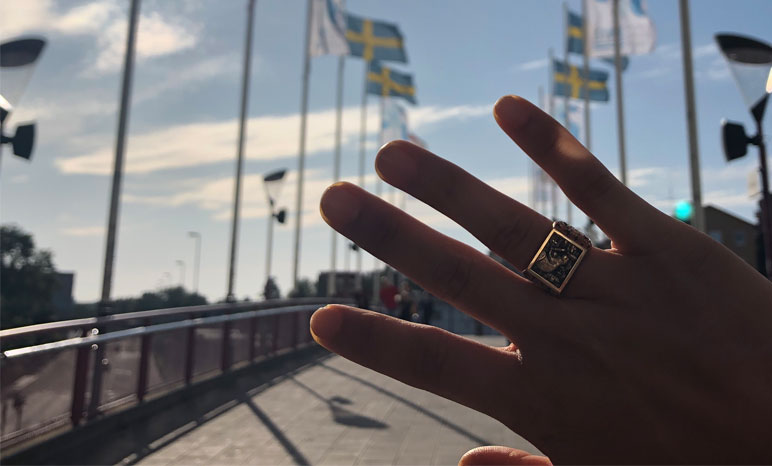 Hand with MIT class ring in front of flags