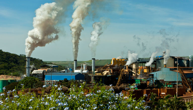 A factory in a grassy area creating emissions