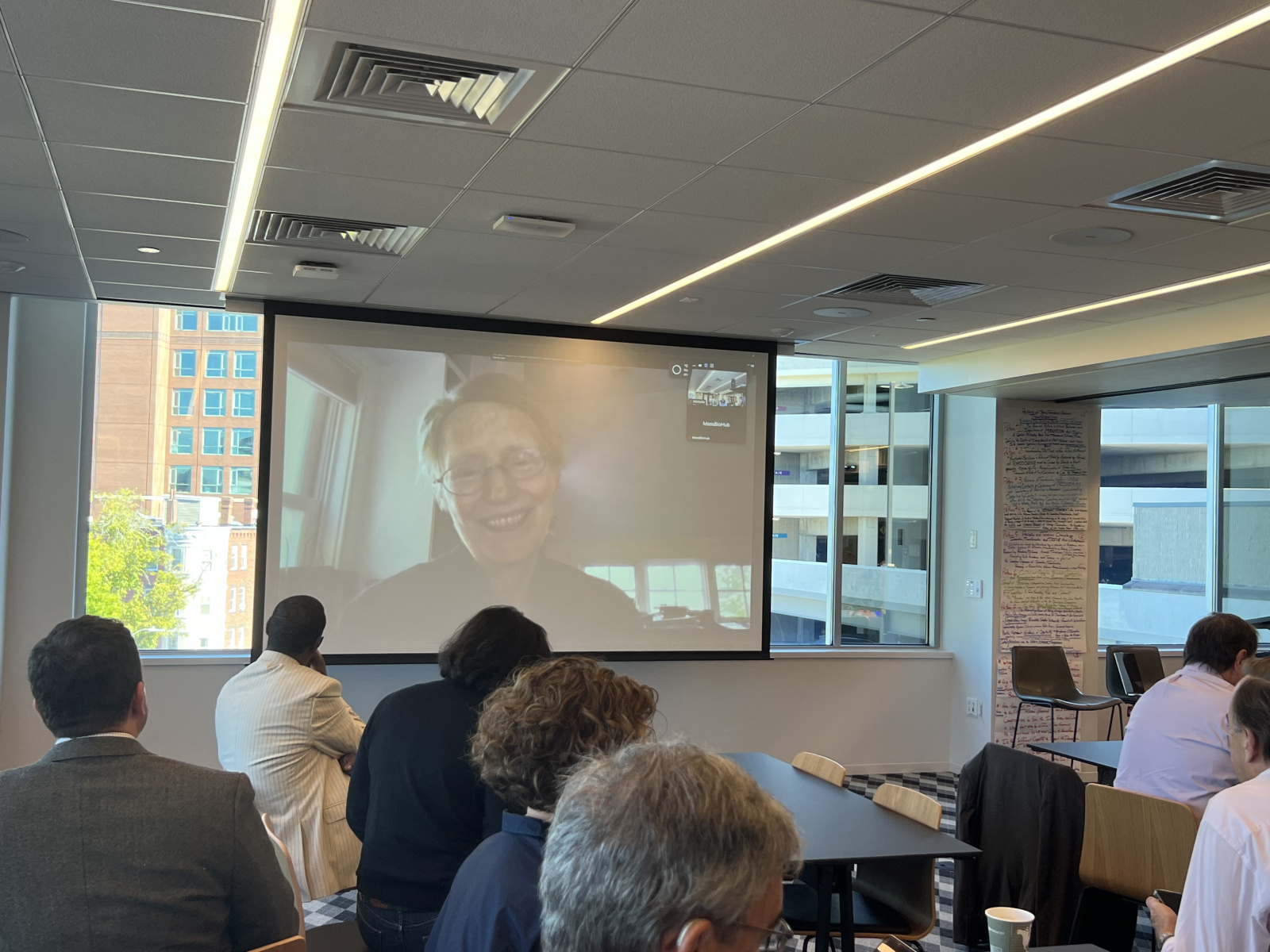 Cynthia Rosenzweig on a large monitor giving a presentation via Zoom