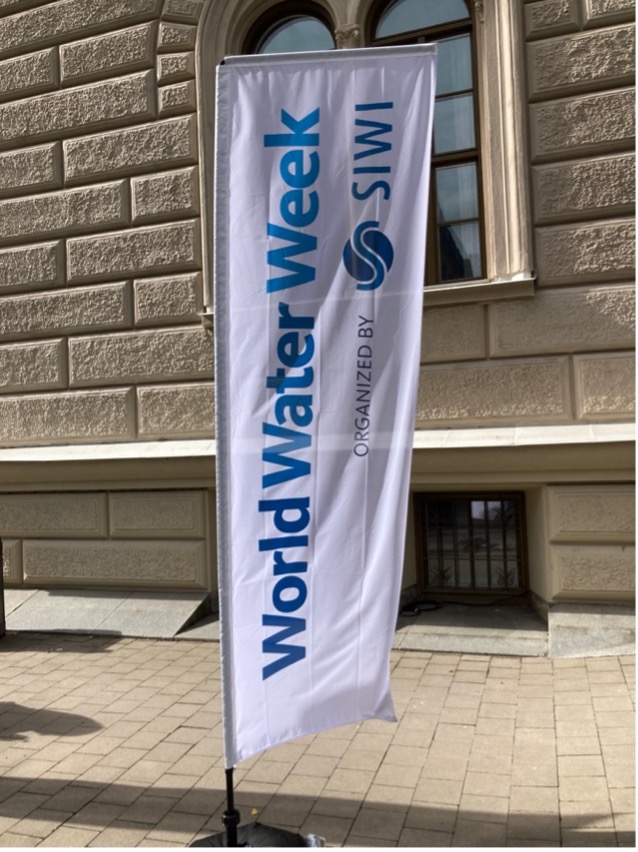 White banner waving vertically outside a building that reads World Water Week SIWI in blue letters