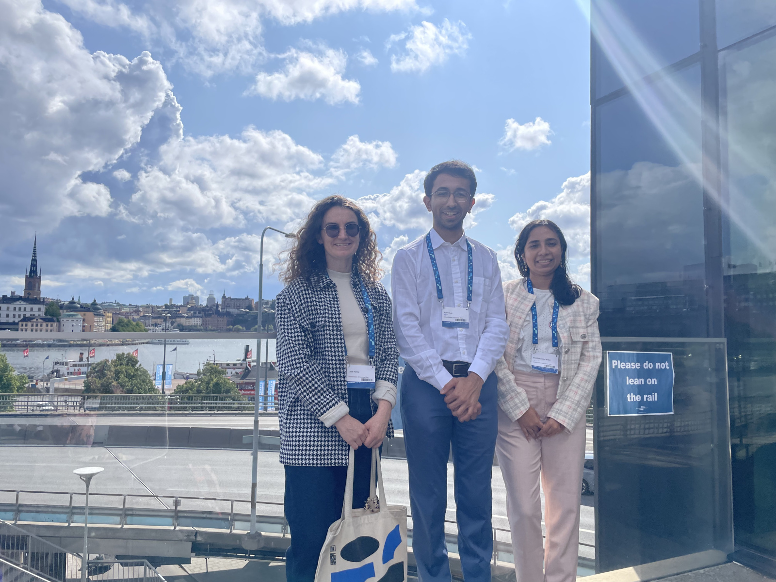 From left to right: Lizzie Yarina, Arjav Shah, and Smriti Bhaya in front of Stockholm landscape