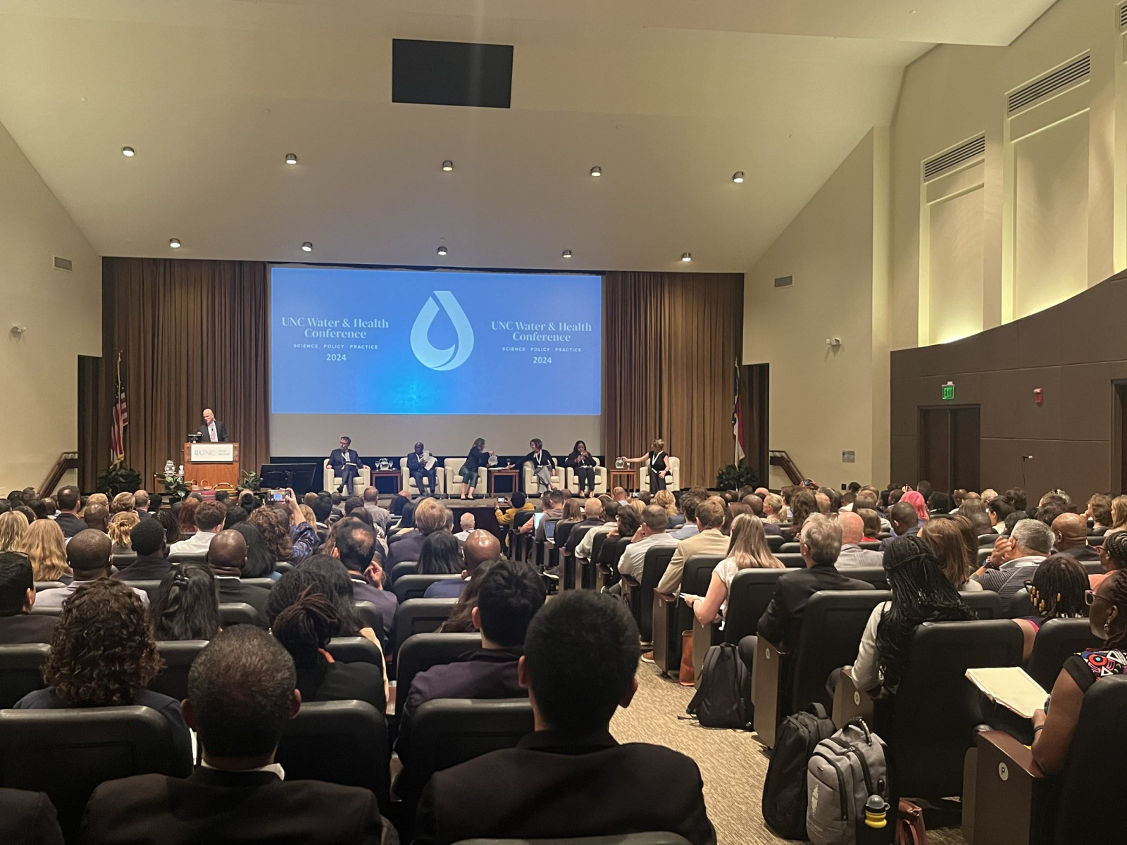 A conference room filled with people attending a panel discussion