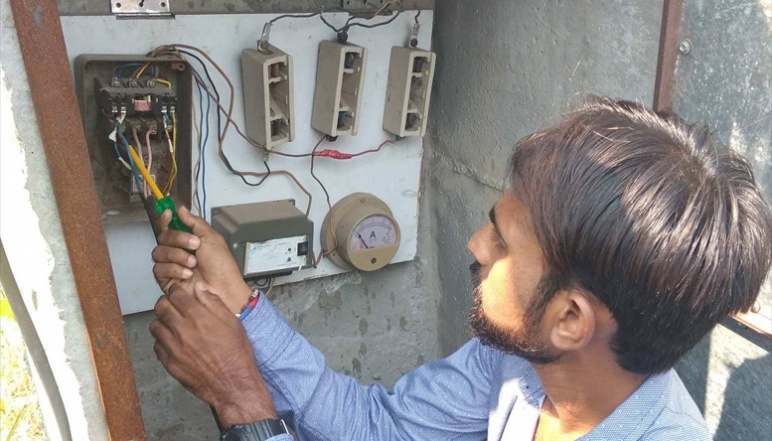 Researcher using screwdriver on hour meter