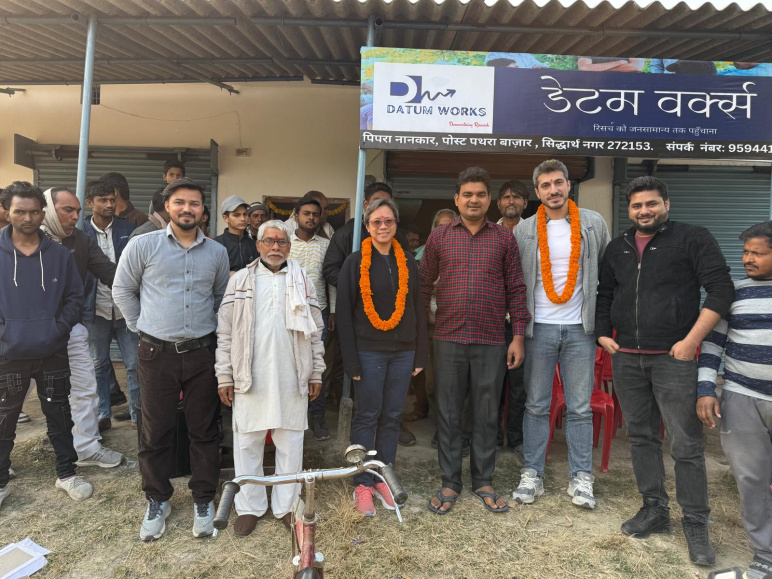 A group of people standing outside in front of a sign that says Datum Works