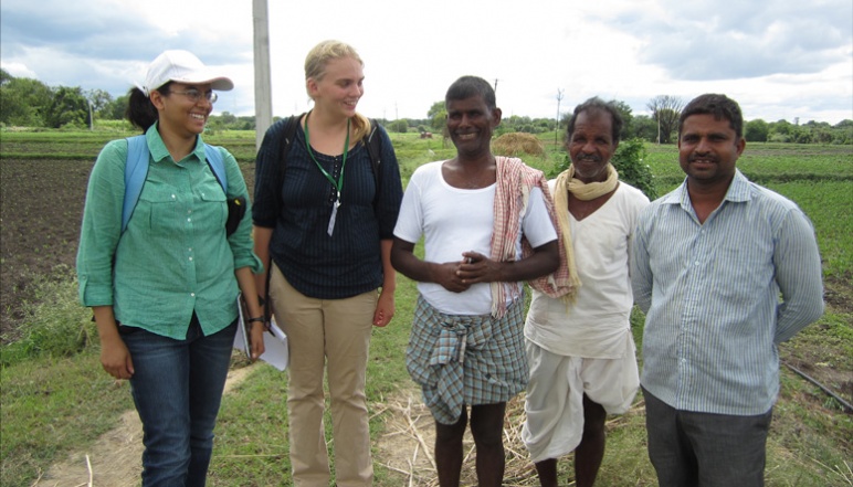 Picture of two research members and local farmers near fields
