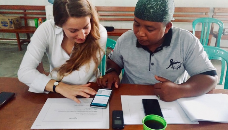 de Zegher sitting with farmer going over mobile model