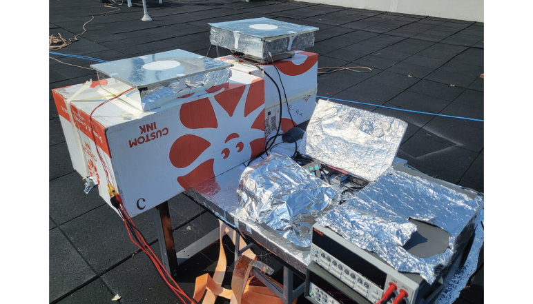 Devices covered in aluminum foil as part of experimental setup for an outdoor cooling experiment on top of a roof