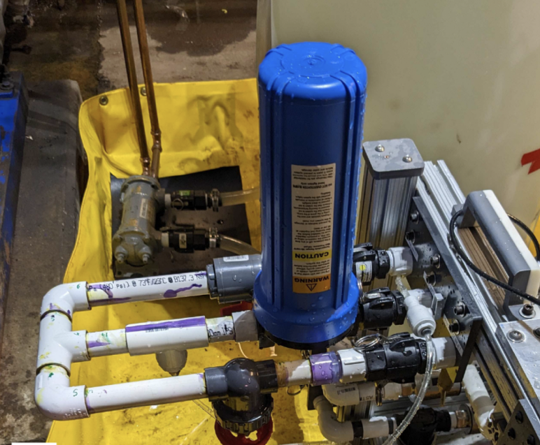 Blue canister attached to three different pipes 