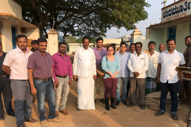 A group of men stand around a researcher in India