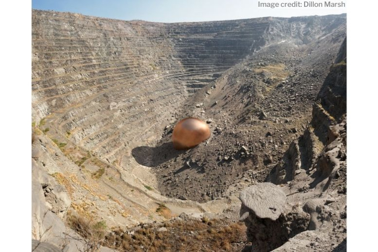 An aerial shot of a mine with a visual representation of the amount of copper extracted compared to the footprint of the extraction