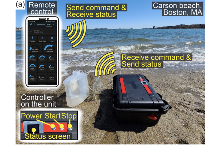 Small black case on the beach sitting next to a jug of water with the ocean in the background. A remote device is photoshopped into the top left corner with another photoshopped image of the power start and stop buttons on the bottom left 
