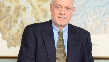 Tim Swager in a suit in front of a painting