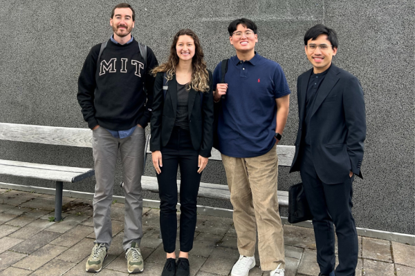 Picture of the 4 MIT students in front of a gray wall
