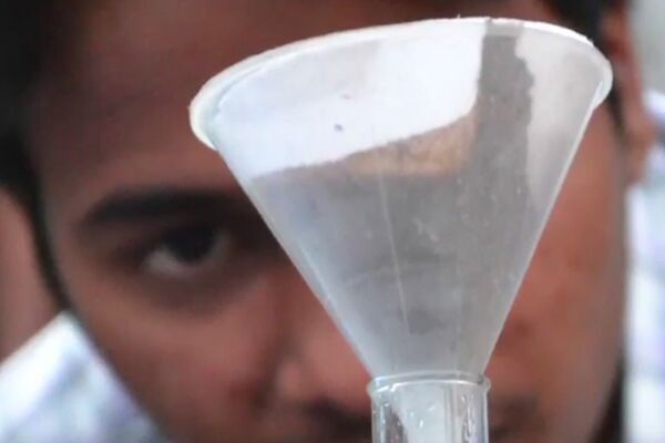 Man looking at soil in a funnel