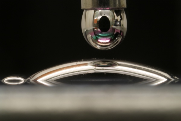 Droplet of mercury coming into contact with a surface and spreading