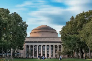 An image of MIT's dome-structured building with green trees on either side. 