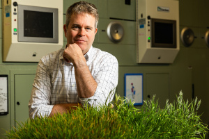 Headshot of J-WAFS PI David in front of bio technology and green plant grass at bottom forefront
