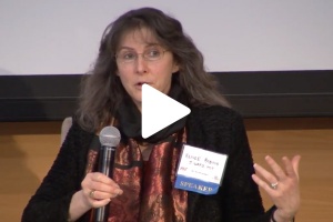 Renee Robins speaking into microphone with play button on image