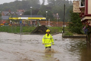Firefighter wading through flooded streets