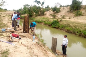 Four men building water infrastructure by Mwache River