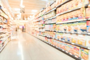 A blurred image of a grocery store aisle filled with processed food