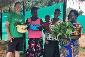 Eric Verploegen, Betty Ikalany, and two vegetable vendors in Uganda