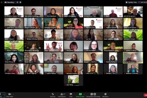 A group of around 40 students and professors smile on a zoom call.