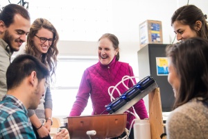 Susan Murcott stands smiling with students