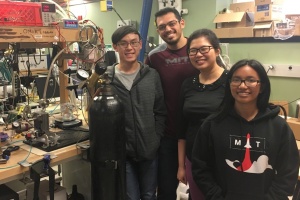 Four student researchers smile in front of a lab bench