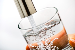 Image of faucet filling glass with water