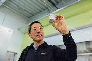 Professor Yet-Ming Chiang holds a mechanical test specimen of decarbonized cement.