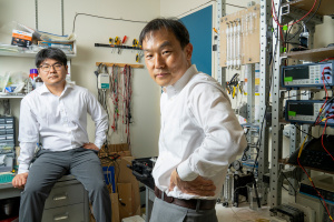 Senior author Jongyoon Han, right, pictured with Junghyo Yoon, seated. They are in a lab setting with many wires and devices.