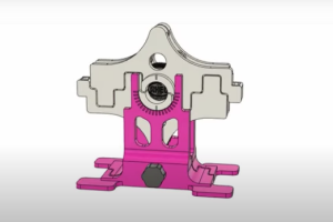 Screenshot of a video of the oreometer in action, which has a pink base and a slot for an oreo to go into with a metal piece on top of the oreo.