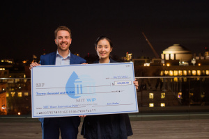 Yajing Zhao and Michael Gangemi of Mesophase standing outside and holding a $20,000 check