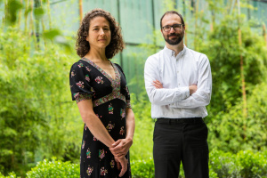 Elsa Olivetti and Rafael Gómez-Bombarelli standing together with plants in the background.