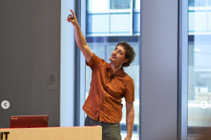 Dan Sweeney presenting with a an orange shirt