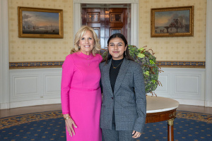 Jill Biden poses arm in arm with Gitanjali Rao in a room of the White House.