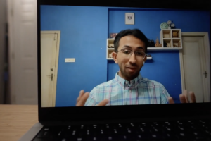 A laptop with Arjav Shah talking on the screen