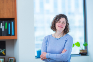 Photo of Mary Gehring in an office, plant on window sill behind her