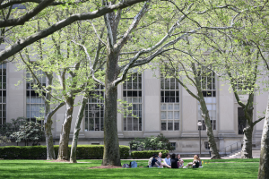 MIT campus graphic of building, trees, and students sitting in grass at forefront