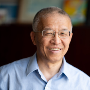 Headshot of Gang Chen in a blue button down shirt and glasses