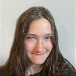 Portrait of Sofia Rutman smiling in front of a blank wall.