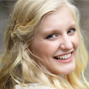 Headshot of Katharina Fransen, looking over shoulder with long blonde hair, smiling