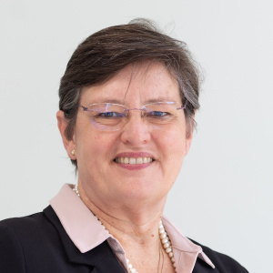 Sheryl L. Hendriks with a pink collared shirt, blazer and glasses