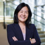 Evelyn Wang standing in front of steps with arms folded in front of her